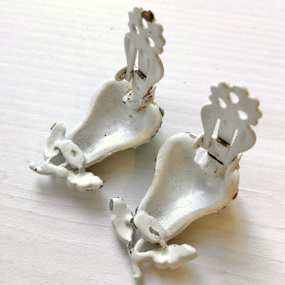 White pear-shaped clip earrings set with turquoise glass stones. ターコイズカラーのガラスストーンが散りばめられた、白い洋梨モチーフのクリップイヤリング。