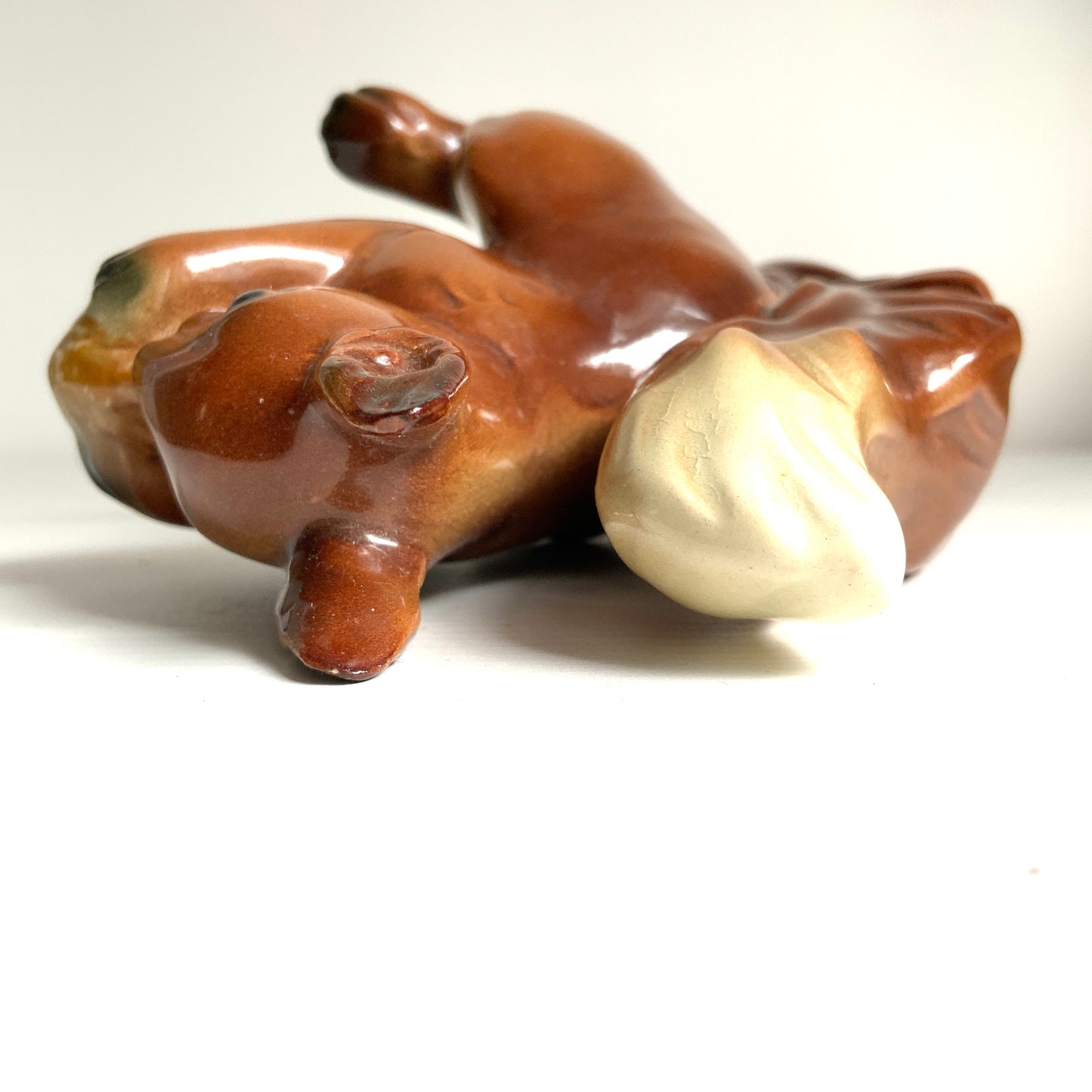 A charming ceramic squirrel figurine holding a nut. ナッツを抱えた、愛らしいセラミック製のリスのフィギュリン。