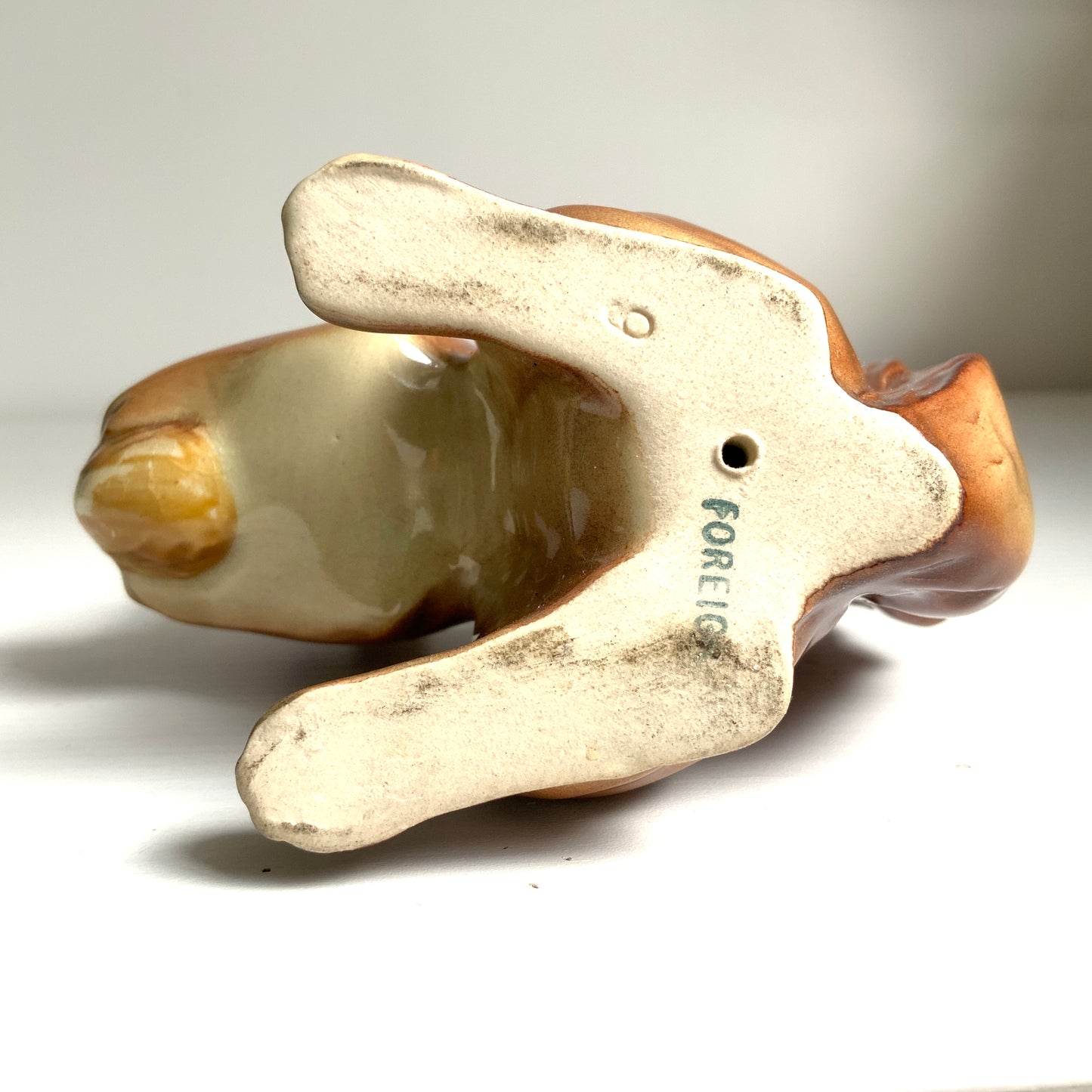A charming ceramic squirrel figurine holding a nut. ナッツを抱えた、愛らしいセラミック製のリスのフィギュリン。