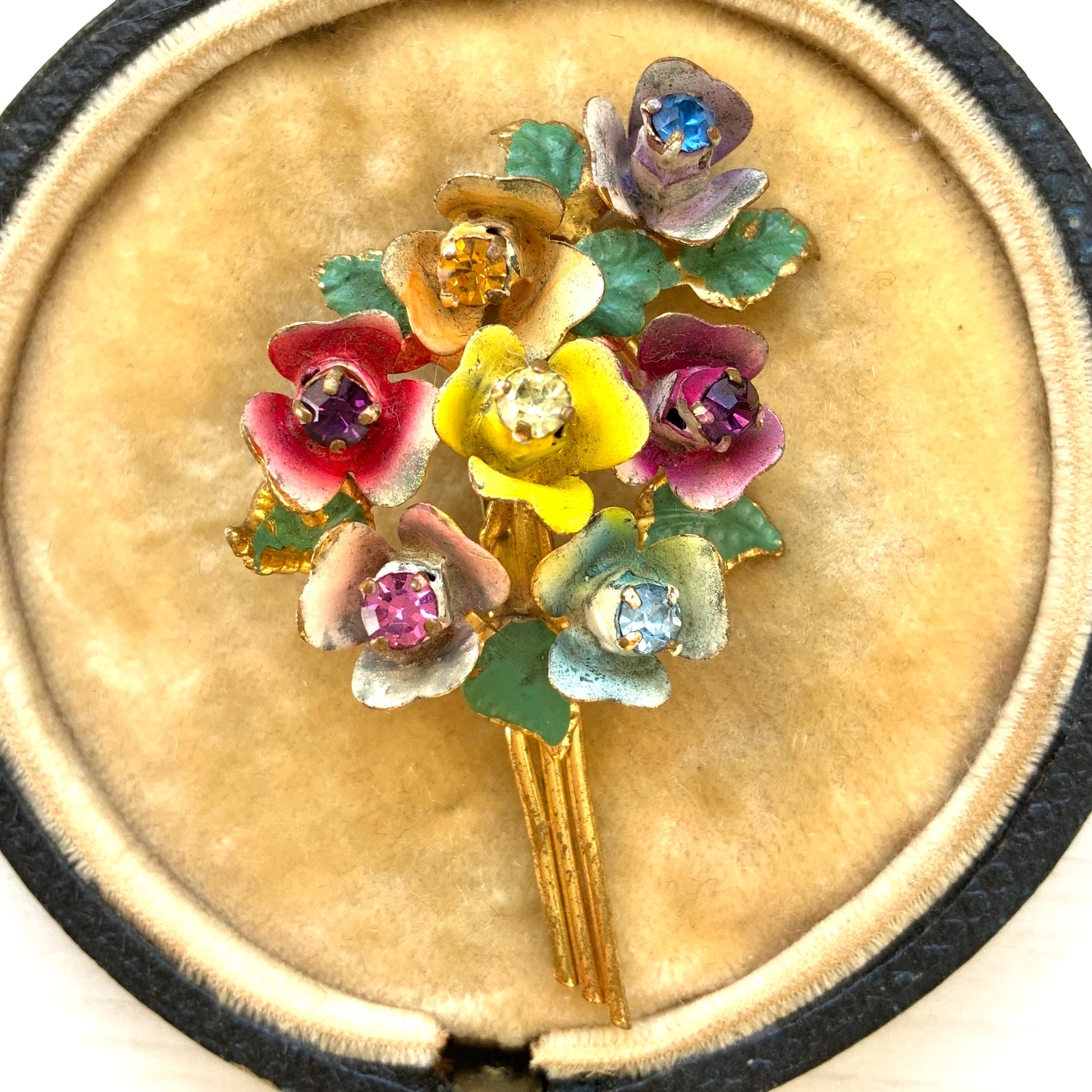 A vintage brooch designed as a colourful bouquet of enamel flowers. 色とりどりの花が束ねられた、エナメルのフラワーブローチ。