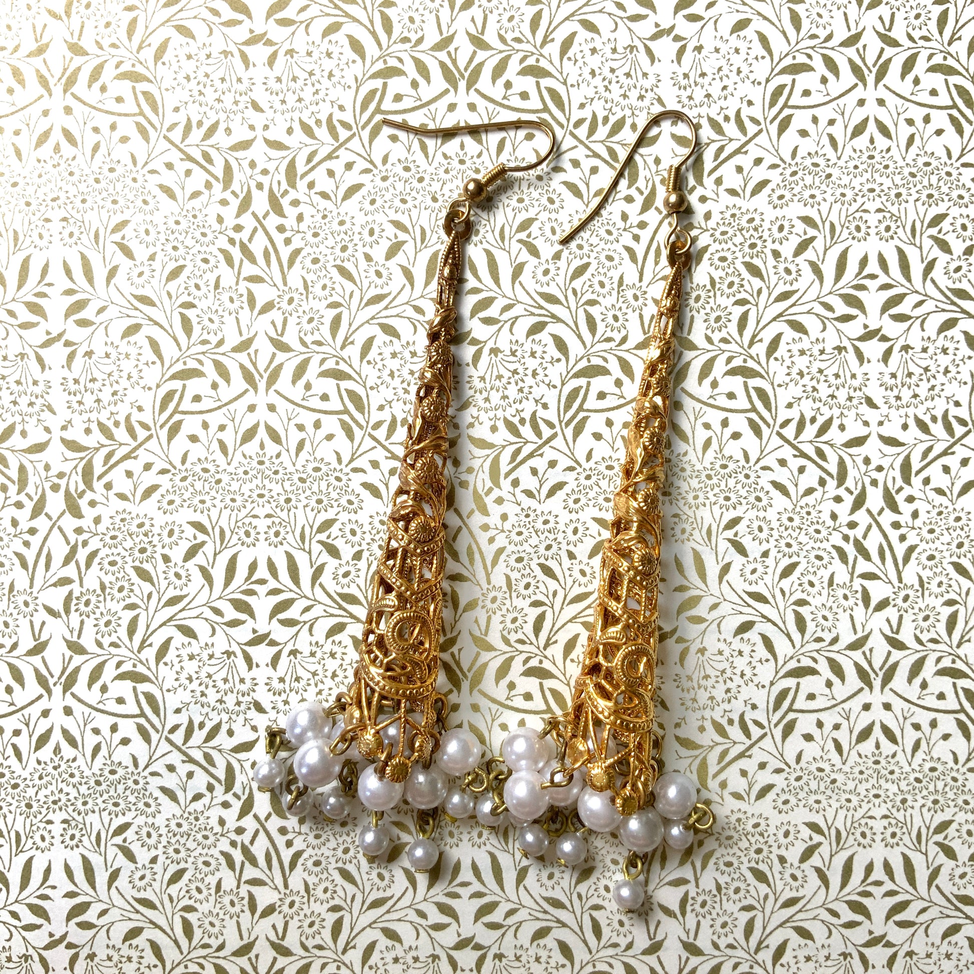 These earrings feature gold-tone filigree cones with faux pearl fringes that dangle elegantly.  ゴールドトーンのフィリグリーのコーンにフォーパールのフリンジが揺れるピアス。