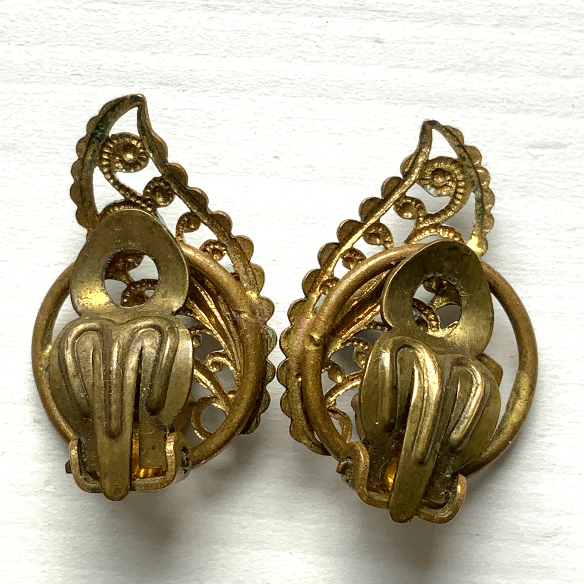 Clip-on earrings in the shape of filigree feathers, delicately painted in light blue. 水色にペイントされたフィリグリーの羽の形のクリップイヤリング。 