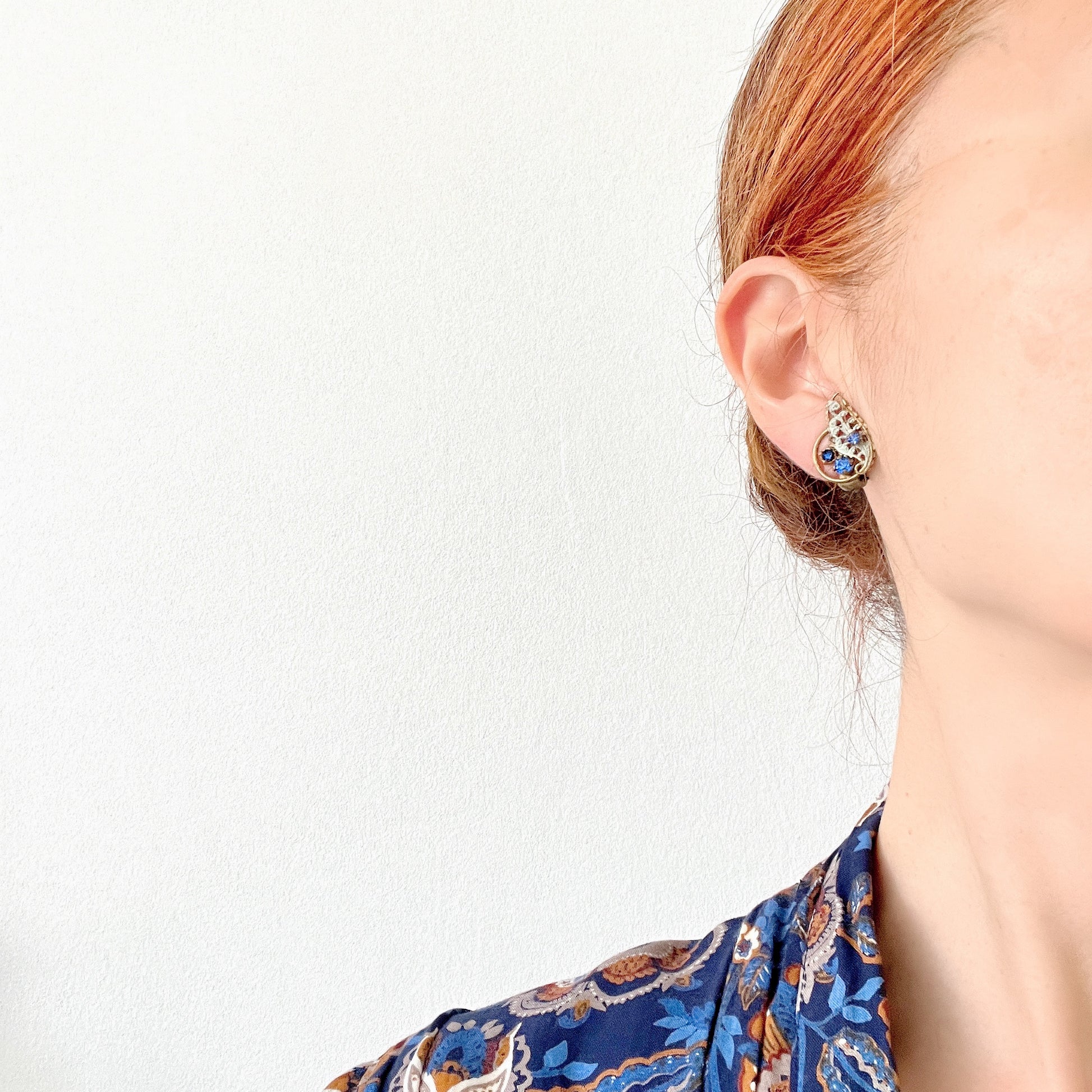 Clip-on earrings in the shape of filigree feathers, delicately painted in light blue. 水色にペイントされたフィリグリーの羽の形のクリップイヤリング。 