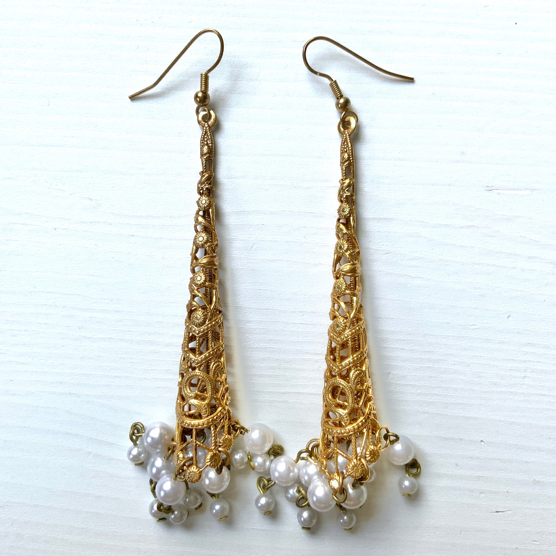 These earrings feature gold-tone filigree cones with faux pearl fringes that dangle elegantly.  ゴールドトーンのフィリグリーのコーンにフォーパールのフリンジが揺れるピアス。