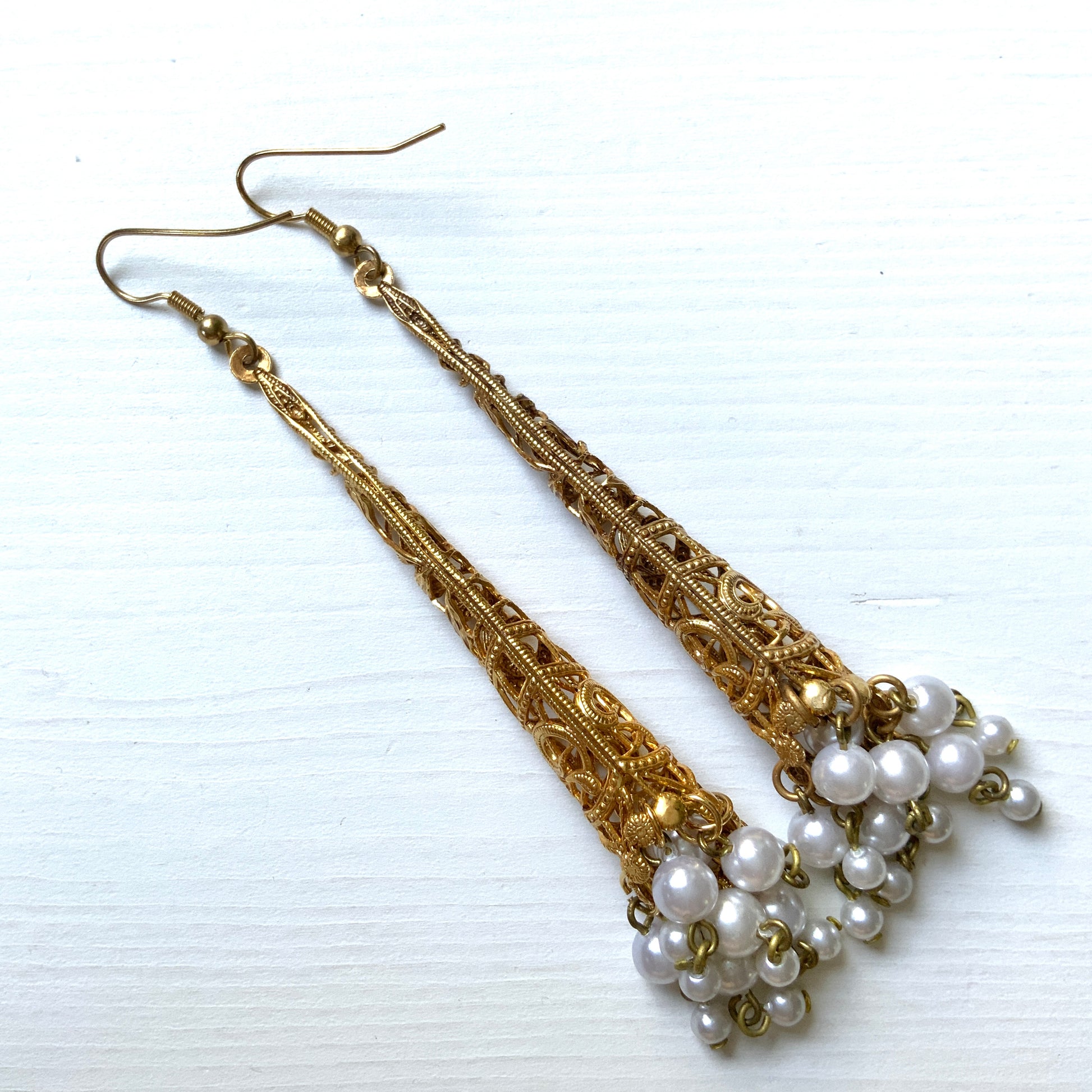 These earrings feature gold-tone filigree cones with faux pearl fringes that dangle elegantly.  ゴールドトーンのフィリグリーのコーンにフォーパールのフリンジが揺れるピアス。
