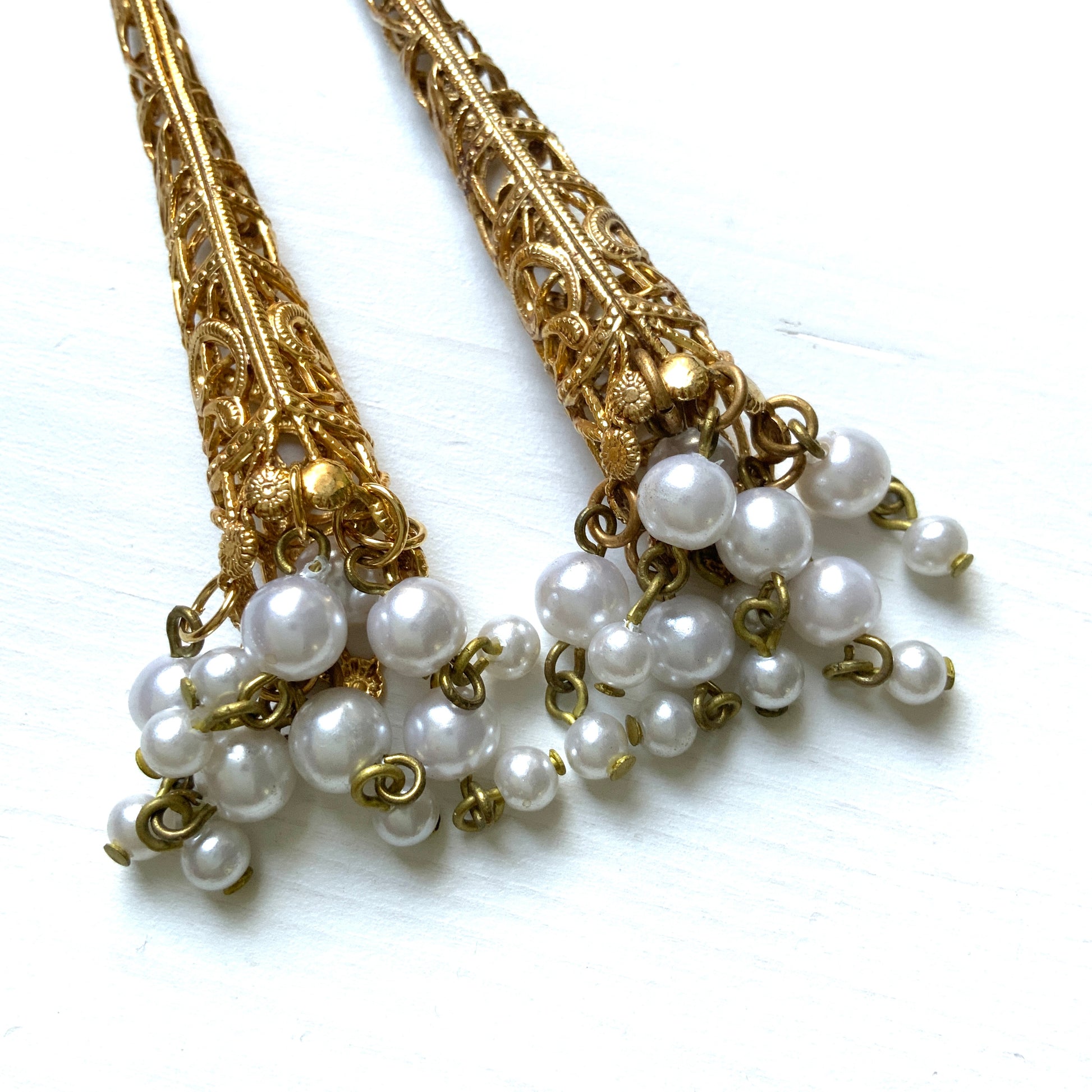 These earrings feature gold-tone filigree cones with faux pearl fringes that dangle elegantly.  ゴールドトーンのフィリグリーのコーンにフォーパールのフリンジが揺れるピアス。