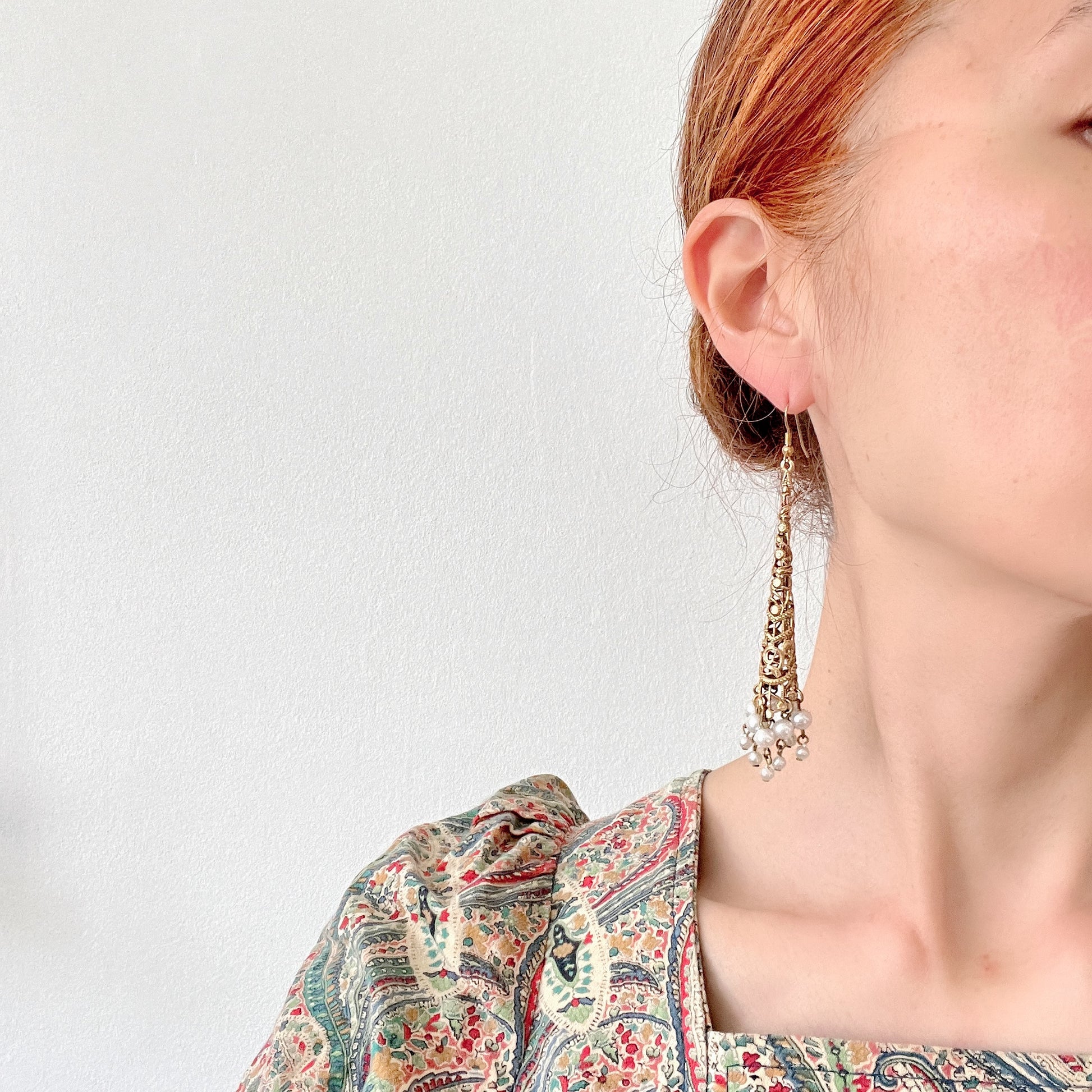 These earrings feature gold-tone filigree cones with faux pearl fringes that dangle elegantly.  ゴールドトーンのフィリグリーのコーンにフォーパールのフリンジが揺れるピアス。