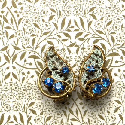 Clip-on earrings in the shape of filigree feathers, delicately painted in light blue. 水色にペイントされたフィリグリーの羽の形のクリップイヤリング。 