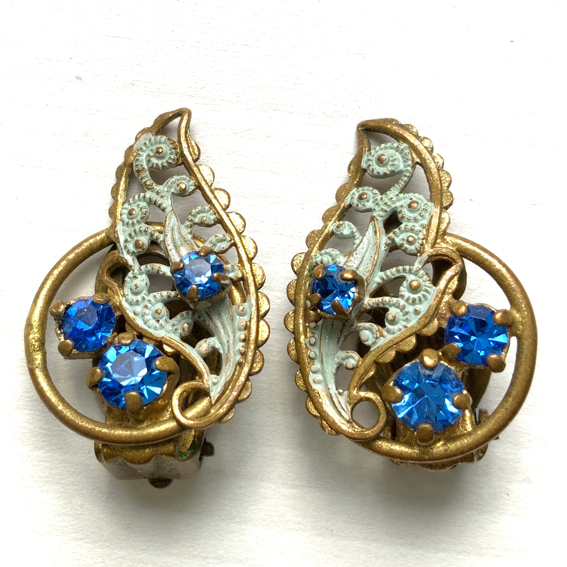 Clip-on earrings in the shape of filigree feathers, delicately painted in light blue. 水色にペイントされたフィリグリーの羽の形のクリップイヤリング。 
