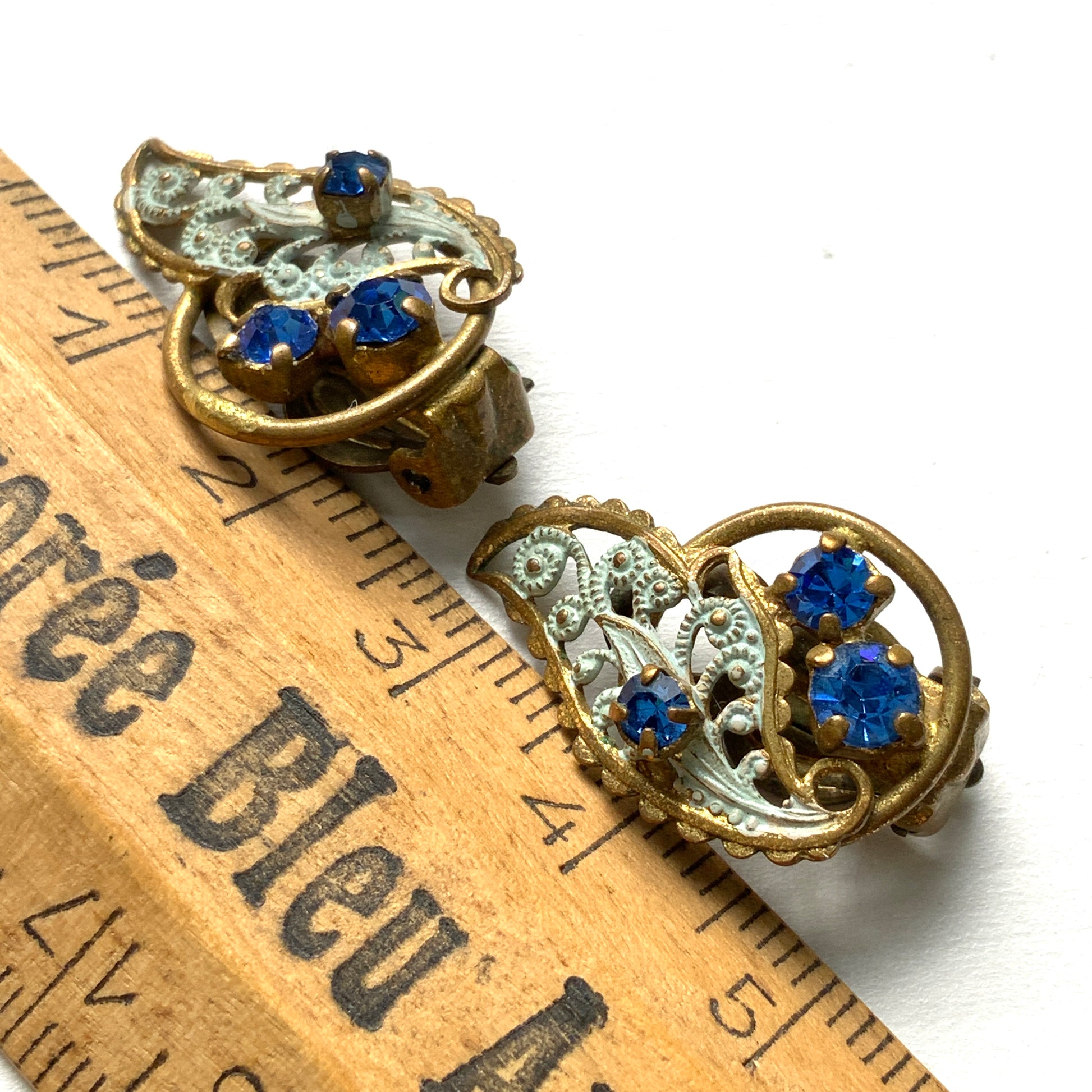 Clip-on earrings in the shape of filigree feathers, delicately painted in light blue. 水色にペイントされたフィリグリーの羽の形のクリップイヤリング。 