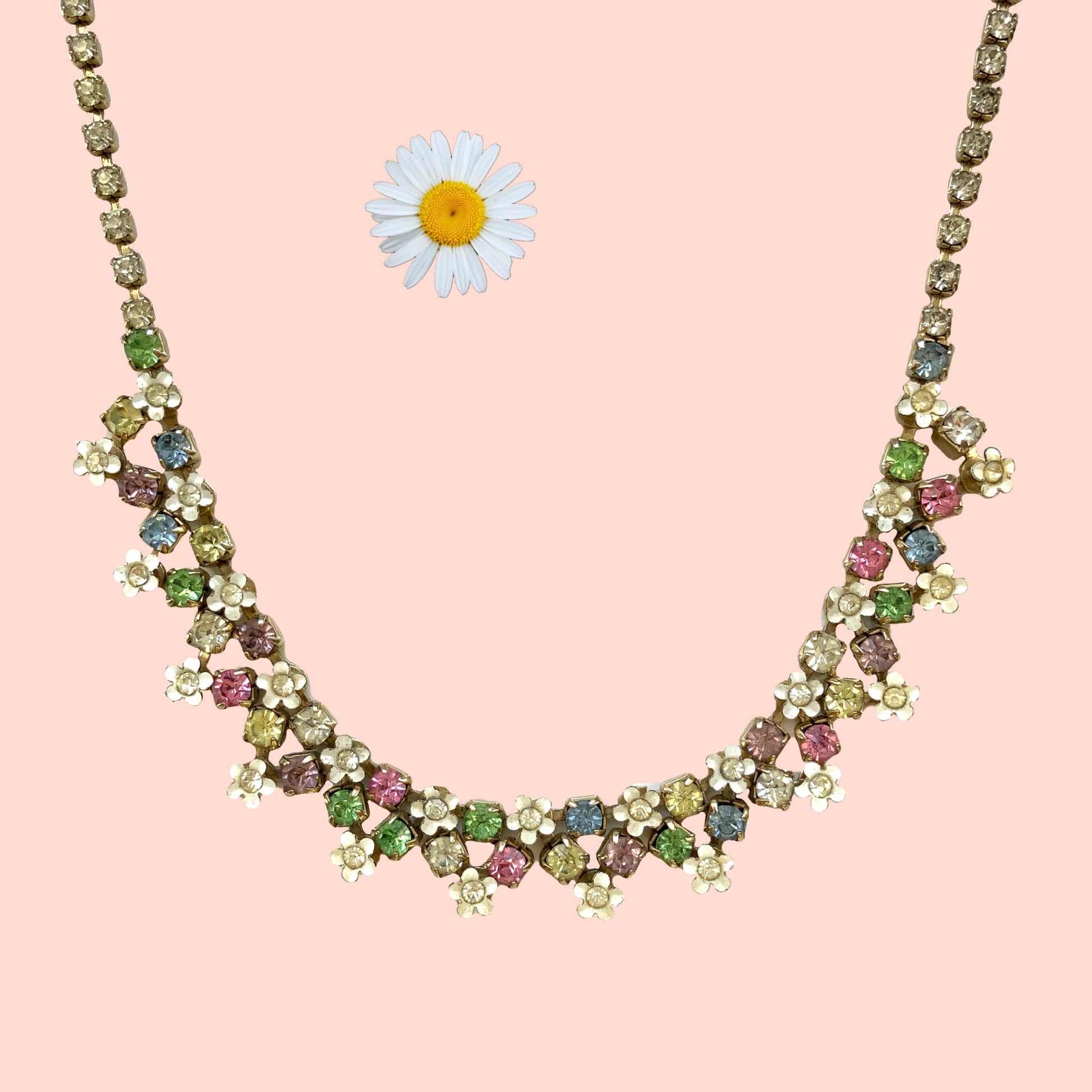 A vintage necklace adorned with white enamel flowers and colourful rhinestones.白いエナメルのお花とカラフルなラインストーンが並んだネックレス。