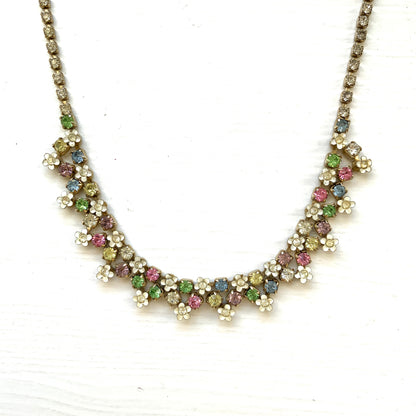 A vintage necklace adorned with white enamel flowers and colourful rhinestones.白いエナメルのお花とカラフルなラインストーンが並んだネックレス。