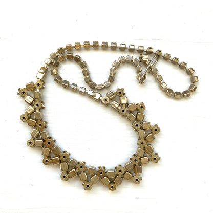 A vintage necklace adorned with white enamel flowers and colourful rhinestones.白いエナメルのお花とカラフルなラインストーンが並んだネックレス。