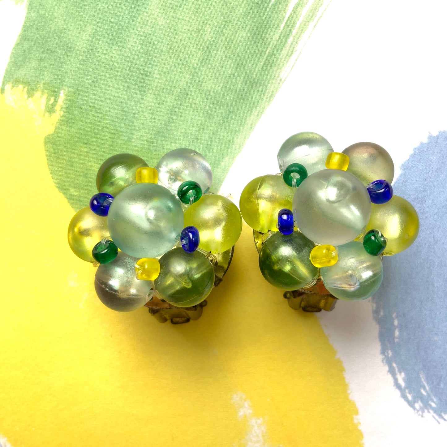 Clip-on earrings featuring frosted beads in refreshing shades of yellow, blue, and green.  イエロー、ブルー、グリーンの爽やかなカラーのフロストビーズのクリップイヤリング。