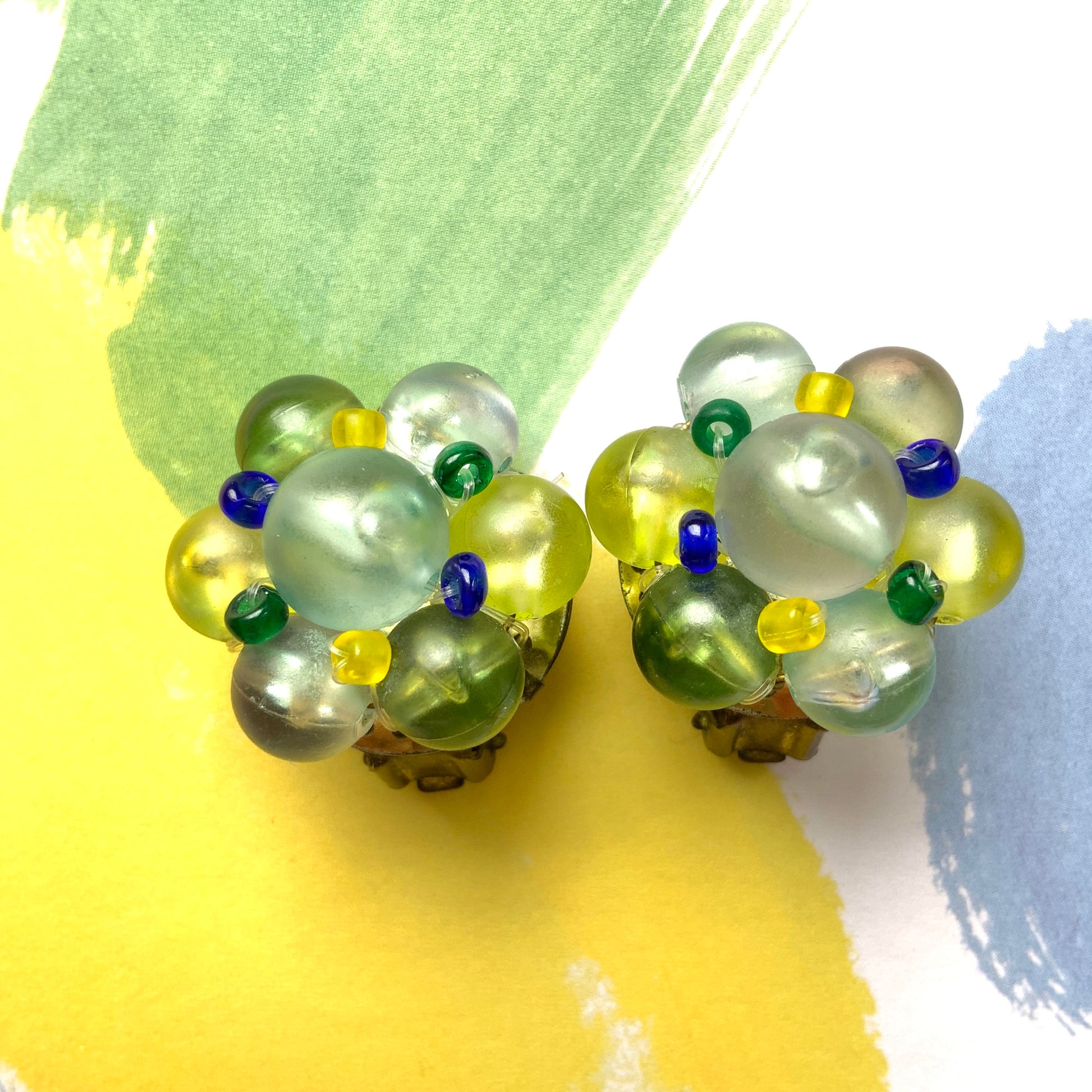 Clip-on earrings featuring frosted beads in refreshing shades of yellow, blue, and green.  イエロー、ブルー、グリーンの爽やかなカラーのフロストビーズのクリップイヤリング。