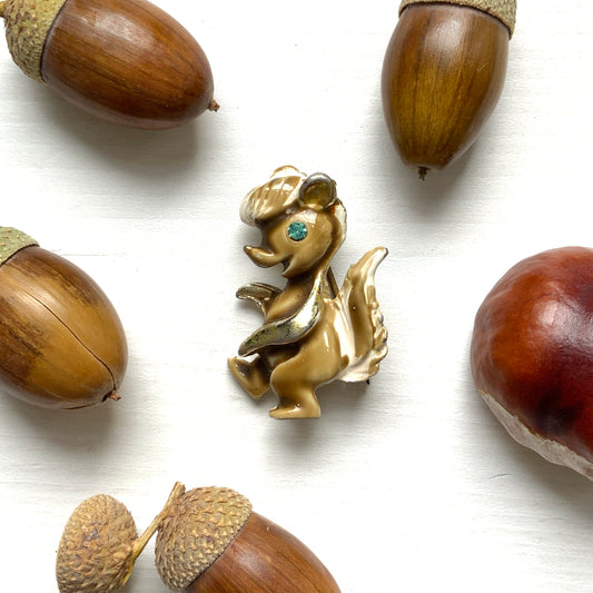A charming mini brooch of an enamel skunk with a maroon-brown coat and a white mane. マロンブラウンの毛並みに白いたてがみが映える、エナメルのスカンクのミニブローチ。 