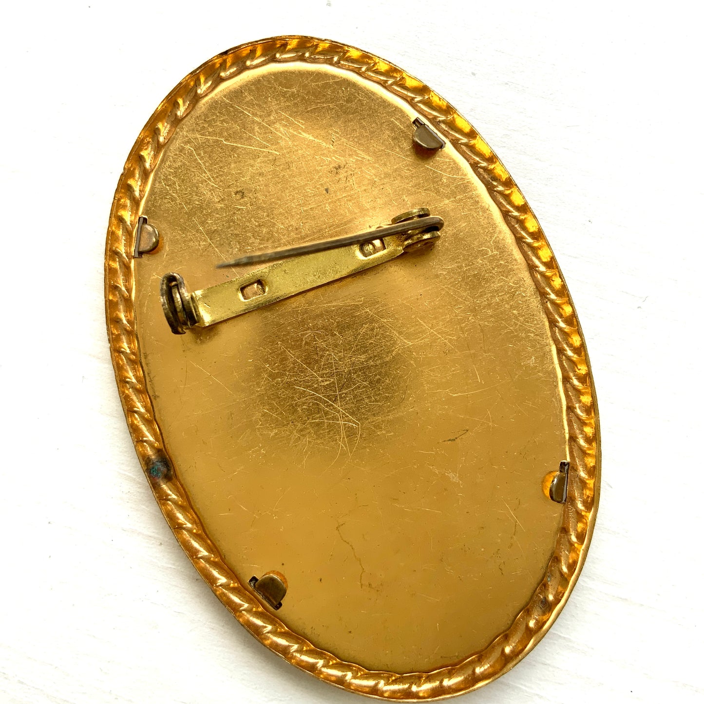 A delicate piece of lace is beautifully framed in a gold-tone setting. 繊細なレースがゴールドトーンのフレームに収められたブローチ。 