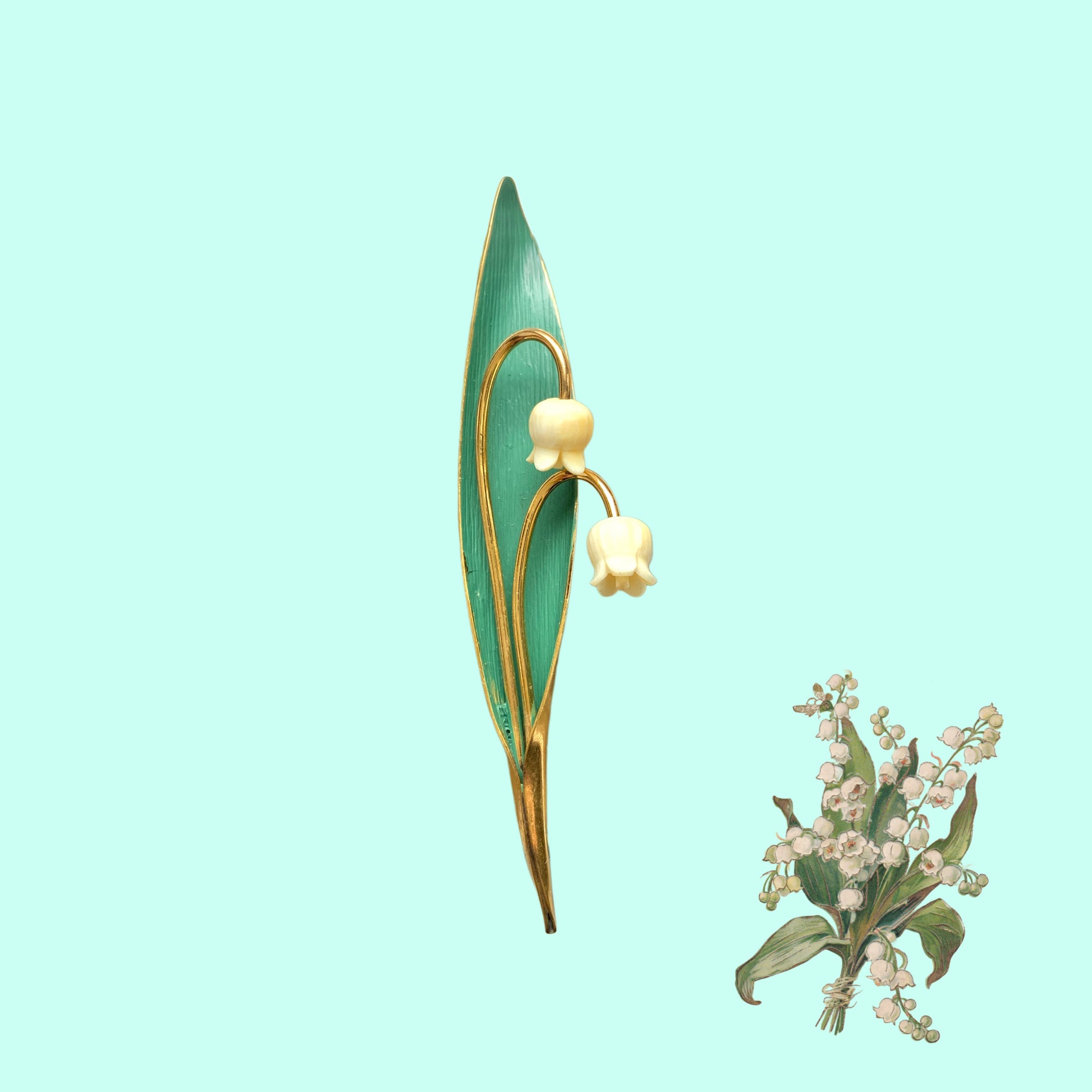 A brooch featuring lily of the valley set against a green enamel leaf. グリーンのエナメルリーフに、スズランをあしらったブローチ。
