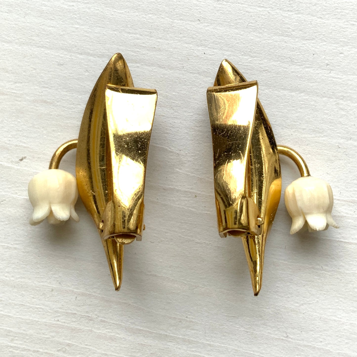 Clip-on earrings featuring green enamel leaves and charming lily of the valley. グリーンのエナメルリーフに、スズランが愛らしいクリップイヤリング。