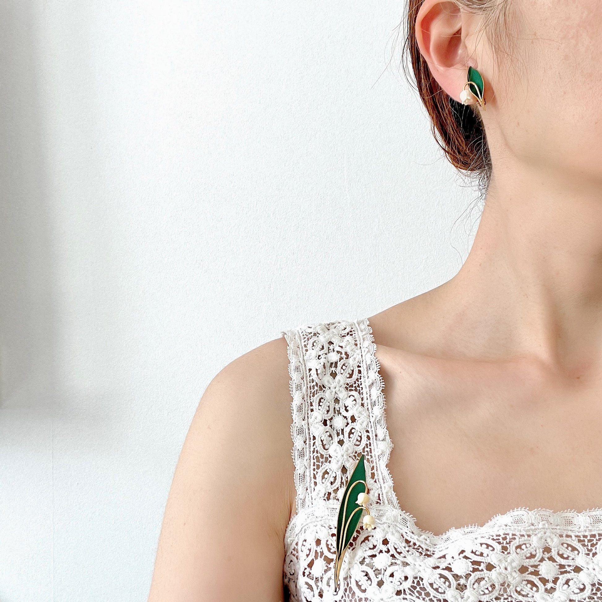 Clip-on earrings featuring green enamel leaves and charming lily of the valley. グリーンのエナメルリーフに、スズランが愛らしいクリップイヤリング。