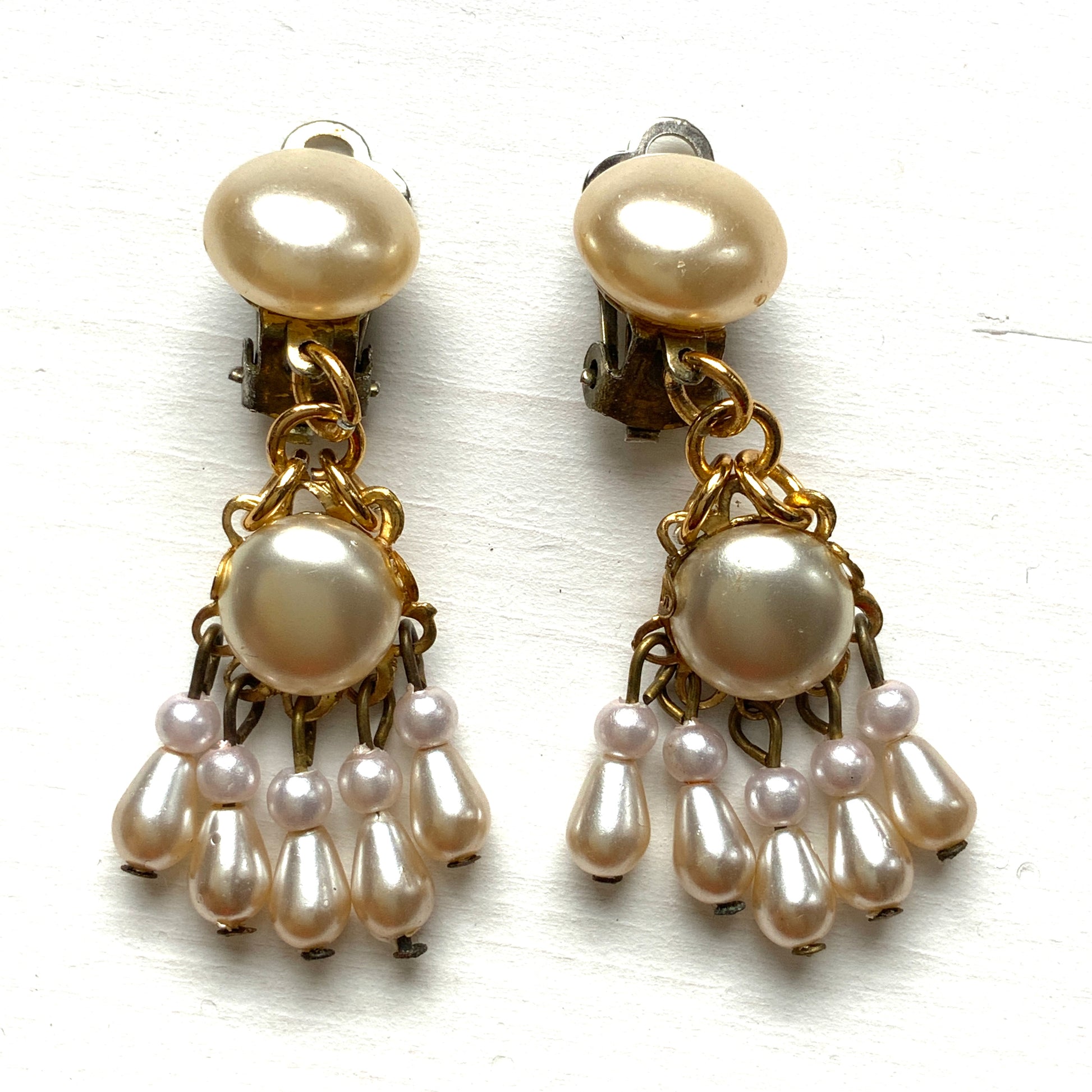 Clip earrings featuring button-shaped faux pearls with a fringe of many teardrop pearls. ボタン型フォーパールにたくさんのティアドロップパールのフリンジが揺れるクリップイヤリング。 