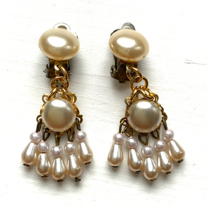 Clip earrings featuring button-shaped faux pearls with a fringe of many teardrop pearls. ボタン型フォーパールにたくさんのティアドロップパールのフリンジが揺れるクリップイヤリング。 