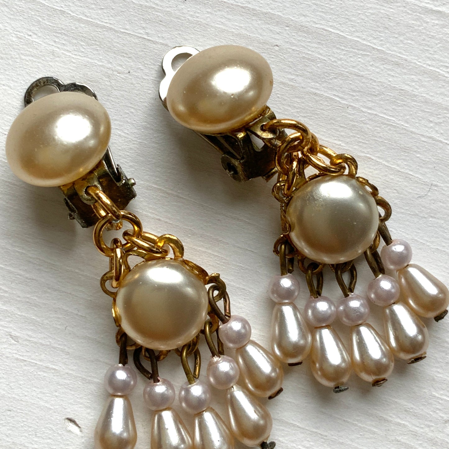 Clip earrings featuring button-shaped faux pearls with a fringe of many teardrop pearls. ボタン型フォーパールにたくさんのティアドロップパールのフリンジが揺れるクリップイヤリング。 