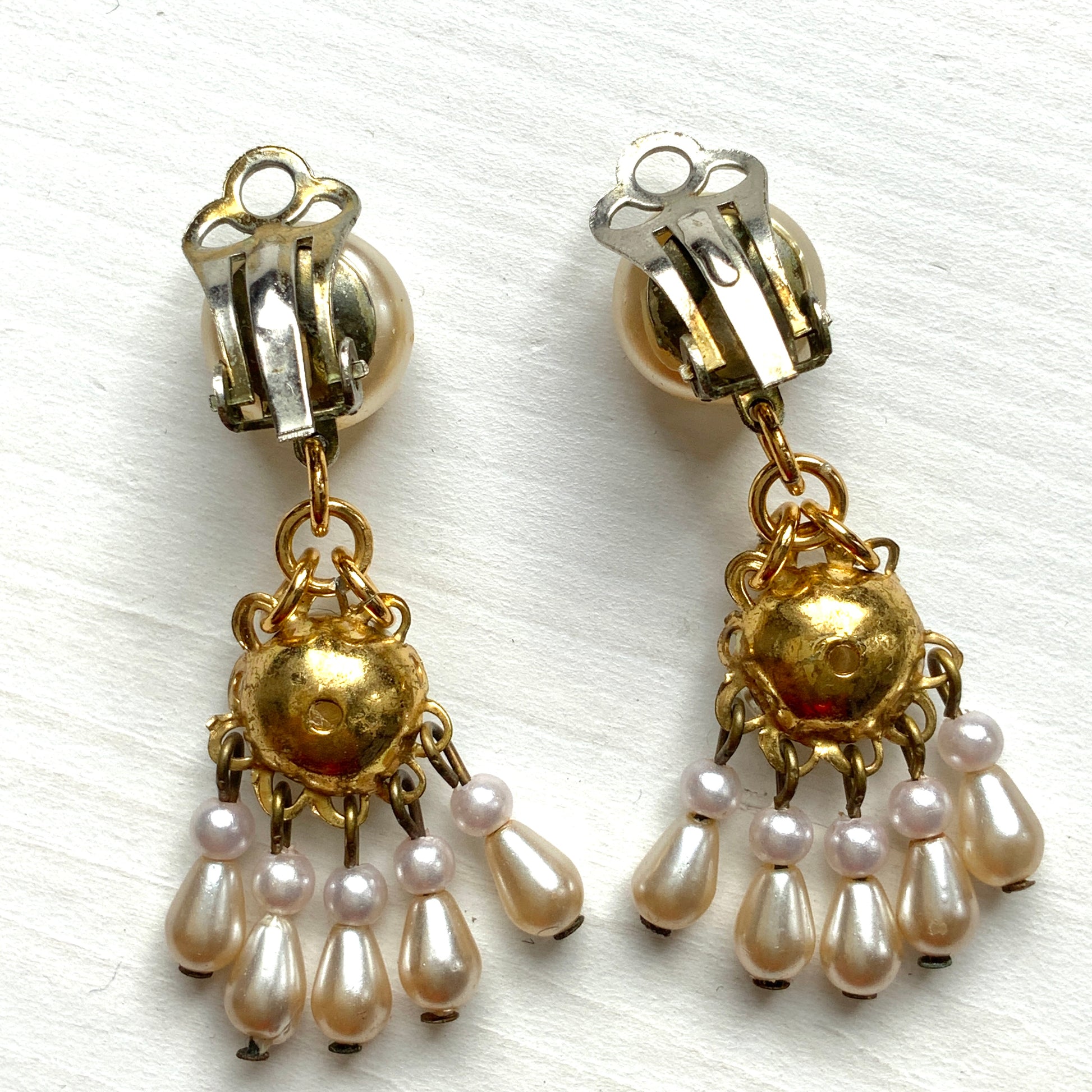Clip earrings featuring button-shaped faux pearls with a fringe of many teardrop pearls. ボタン型フォーパールにたくさんのティアドロップパールのフリンジが揺れるクリップイヤリング。 