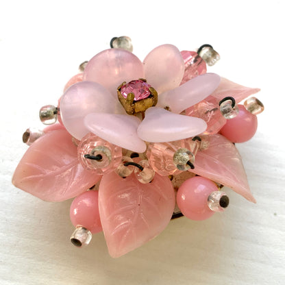A floral brooch combining frosted glass, rhinestones, crystal beads and plastic elements.  フロストガラスやラインストーン、クリスタルビーズ、プラスチックなど、異なる素材を組み合わせたフラワーブローチ。