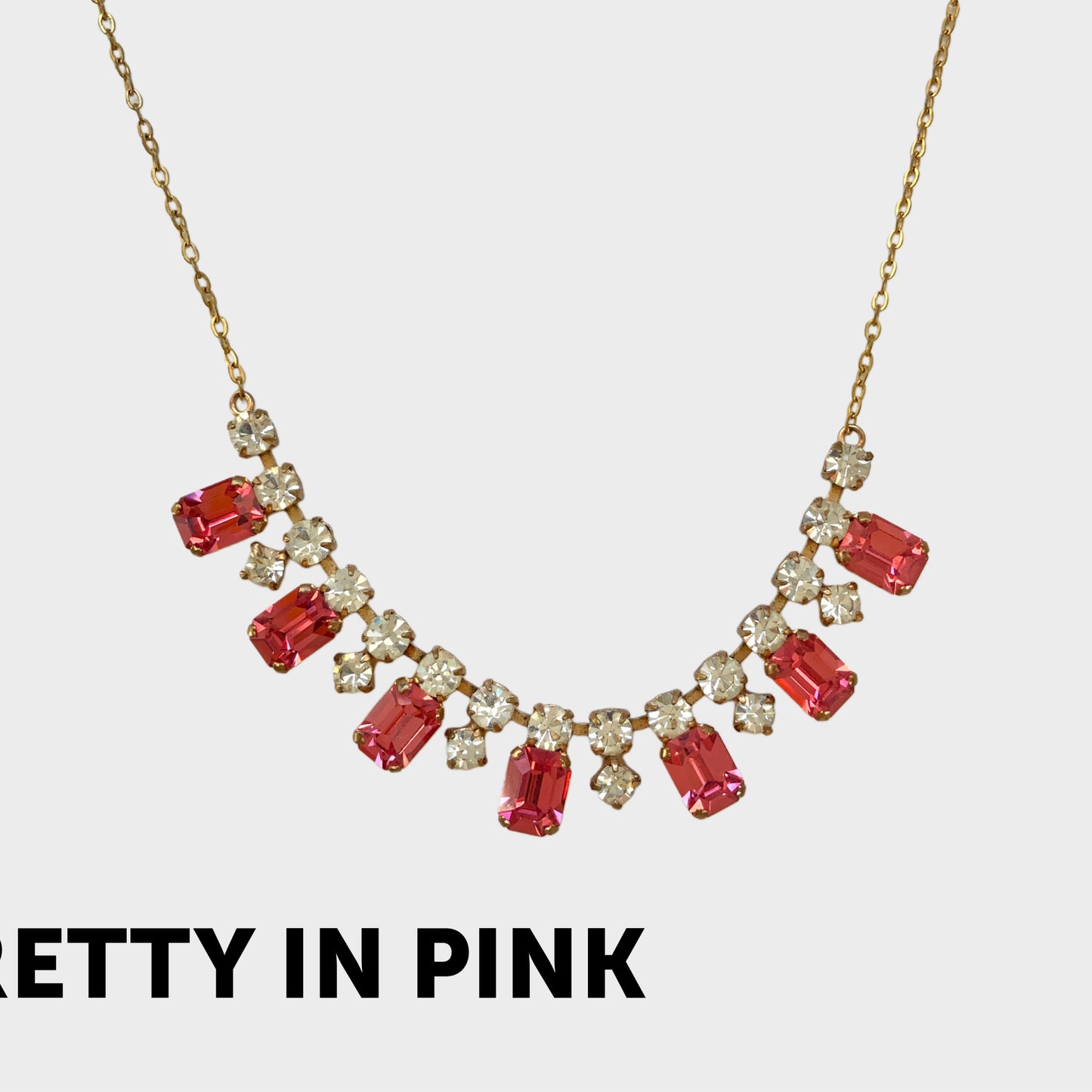 A necklace featuring pink and clear rhinestones. ピンクとクリアのラインストーンを組み合わせたネックレス。