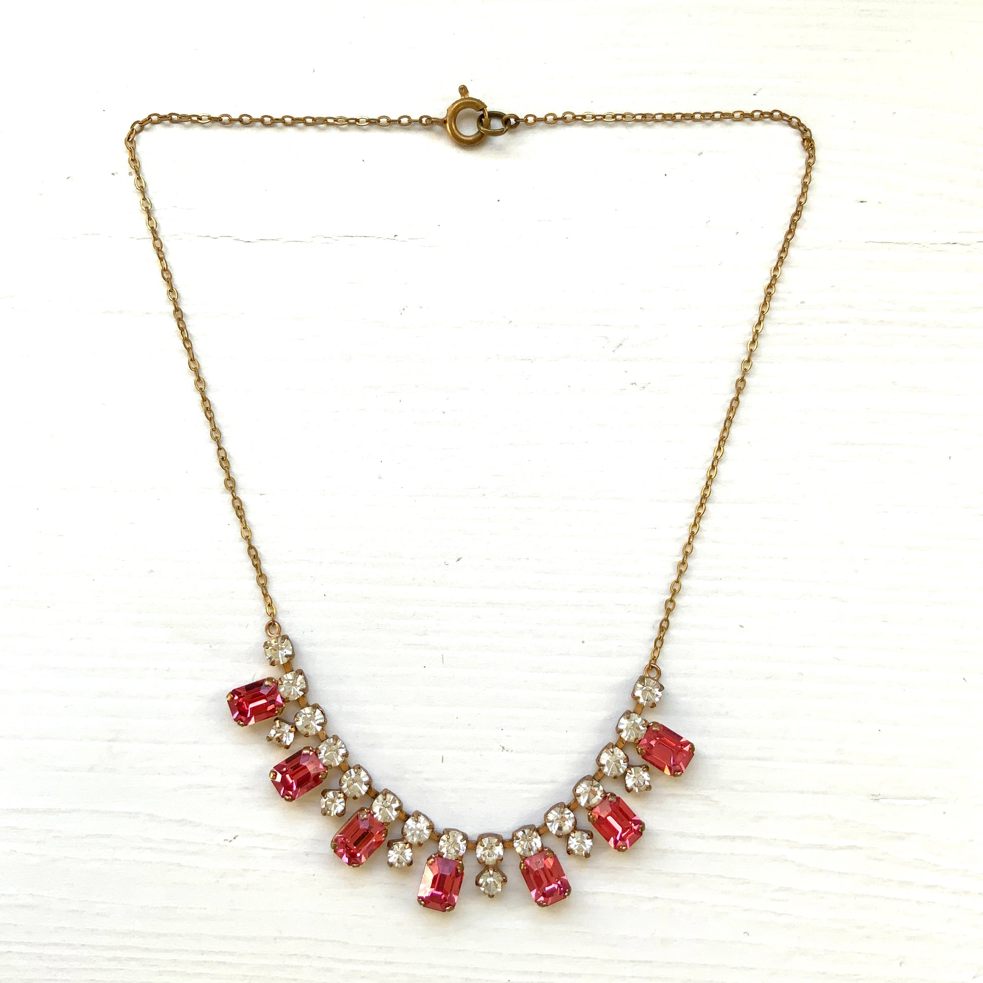 A necklace featuring pink and clear rhinestones. ピンクとクリアのラインストーンを組み合わせたネックレス。