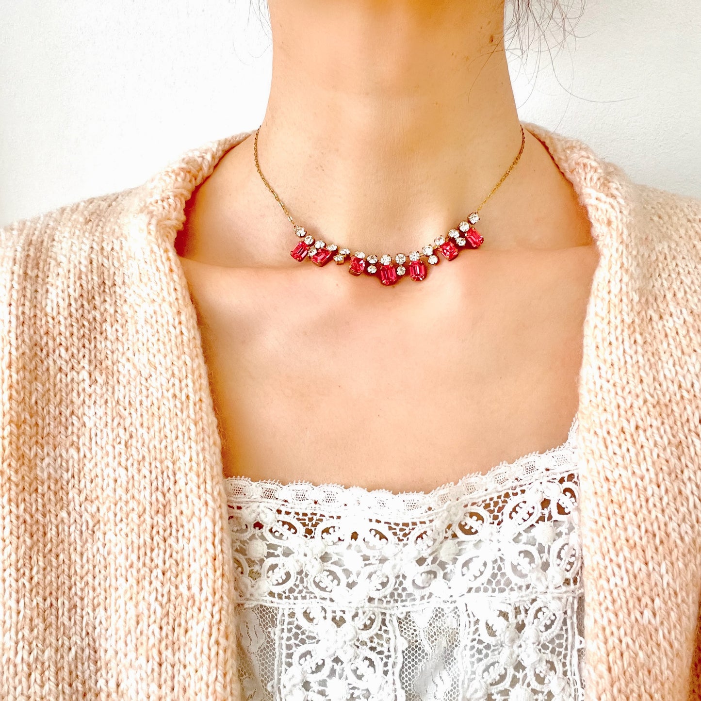 A necklace featuring pink and clear rhinestones. ピンクとクリアのラインストーンを組み合わせたネックレス。