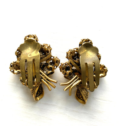Clip-on earrings featuring a bouquet of gold-tone flowers adorned with amber, yellow, and orange rhinestones. ゴールドトーンのお花を、アンバー・イエロー・オレンジ系のラインストーンでブーケに仕立てたクリップイヤリング。 