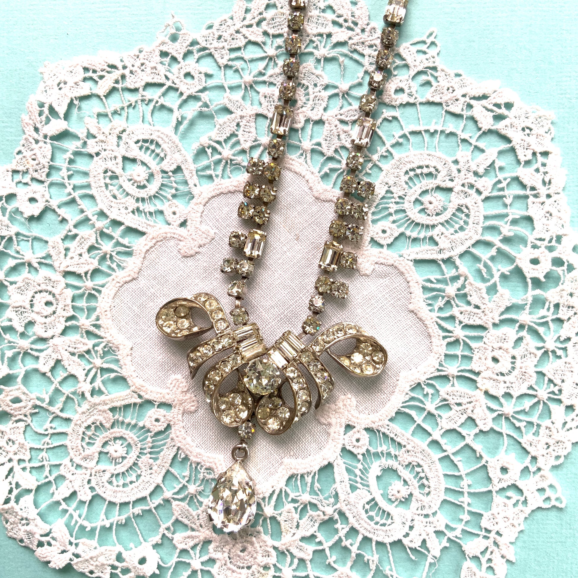 A gorgeous necklace featuring a ribbon-like motif set with clear rhinestones. ゴージャスなクリアラインストーンの、リボンのようなモチーフがついたネックレス。 