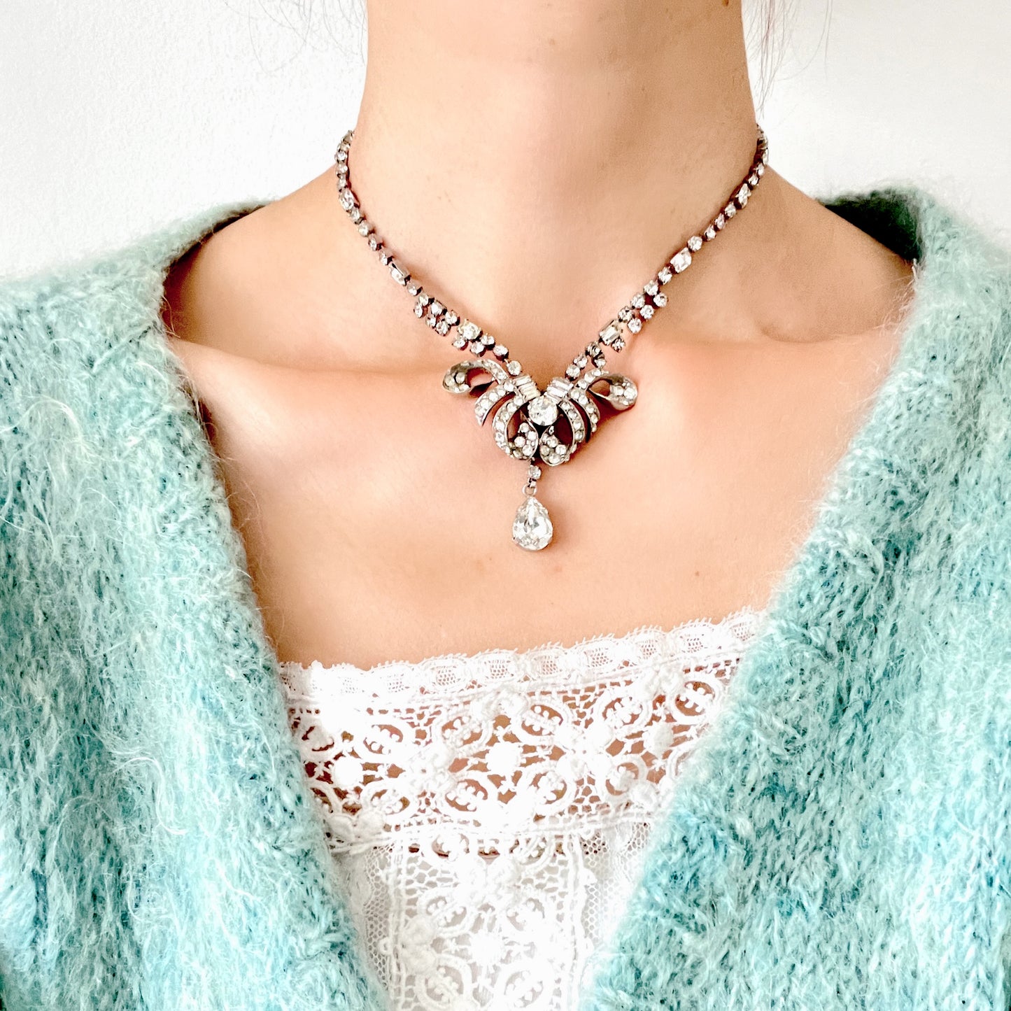 A gorgeous necklace featuring a ribbon-like motif set with clear rhinestones. ゴージャスなクリアラインストーンの、リボンのようなモチーフがついたネックレス。 