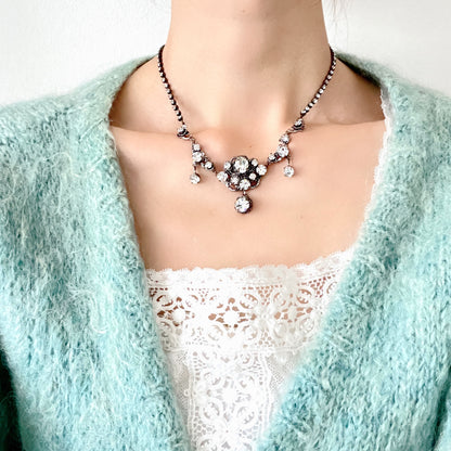 A delicate filigree setting highlights this clear rhinestone necklace. 繊細なフィリグリーが映えるクリアラインストーンのネックレス。