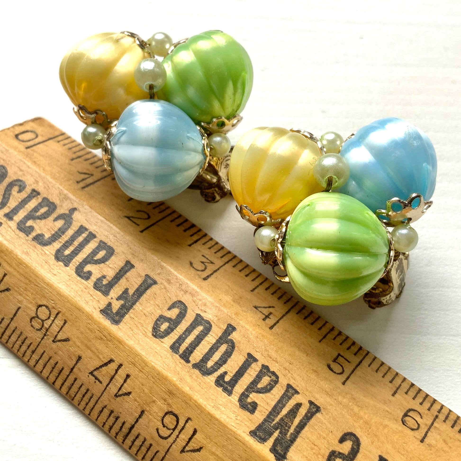  Clip-on earrings featuring soft pastel-coloured satin plastic beads in yellow, blue, and green. イエロー、ブルー、グリーンの柔らかいパステルカラーのサテンプラスチックビーズのクリップイヤリング。