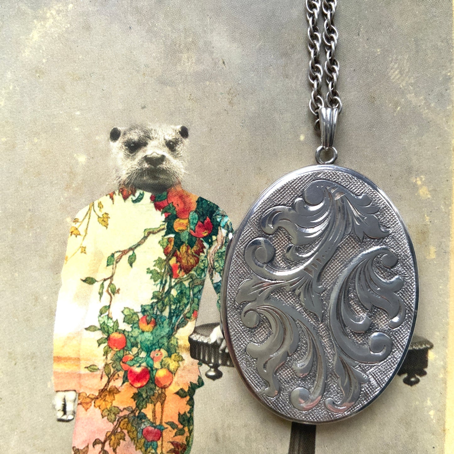 A silver locket necklace beautifully engraved with an elegant botanical motif.  美しい植物模様が彫られた、シルバーのロケットネックレス。