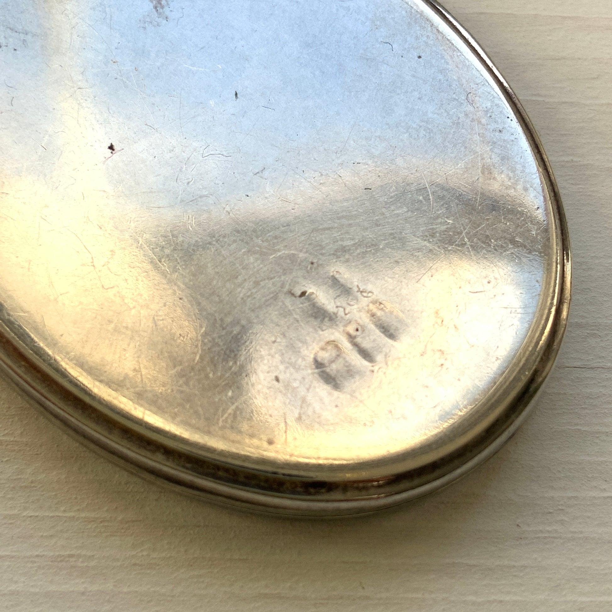 A silver locket necklace beautifully engraved with an elegant botanical motif.  美しい植物模様が彫られた、シルバーのロケットネックレス。