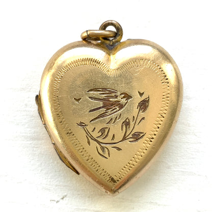 A heart-shaped rolled gold locket engraved with a charming swallow motif. かわいらしいツバメが彫られた、ハート型のロールドゴールドのロケット。