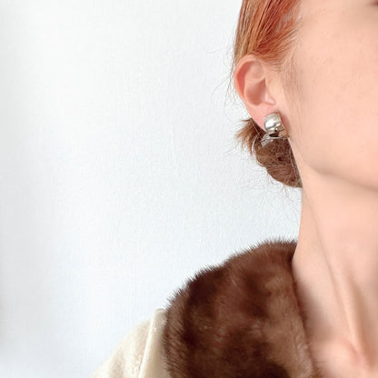 Clip-on door knocker earrings featuring amber-coloured plastic hoops. アンバーカラーのプラスチックフープが揺れる、ドアノッカータイプのクリップイヤリング。