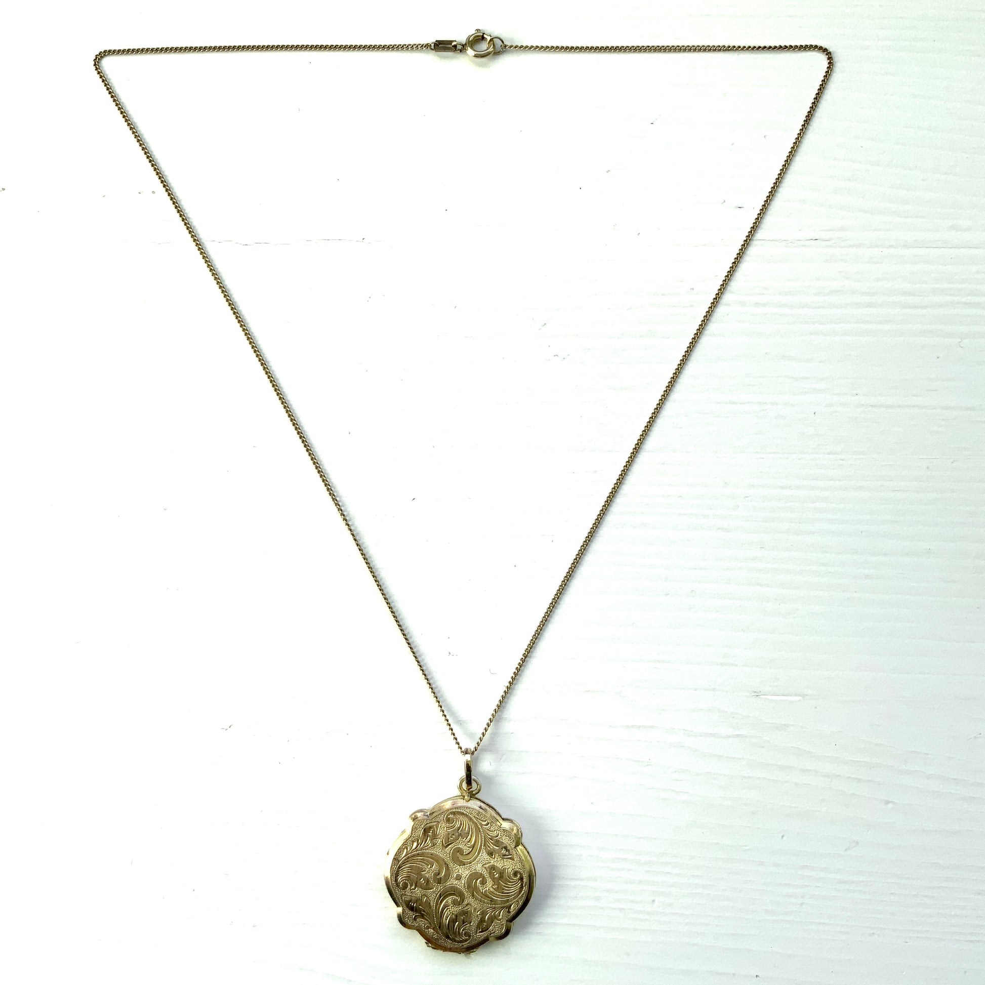 A rolled gold locket by Andreas Daub, beautifully decorated with an elegant foliate pattern. T 美しい植物模様が施された、アンドレアス・ダウブによるロールドゴールドのロケット。 