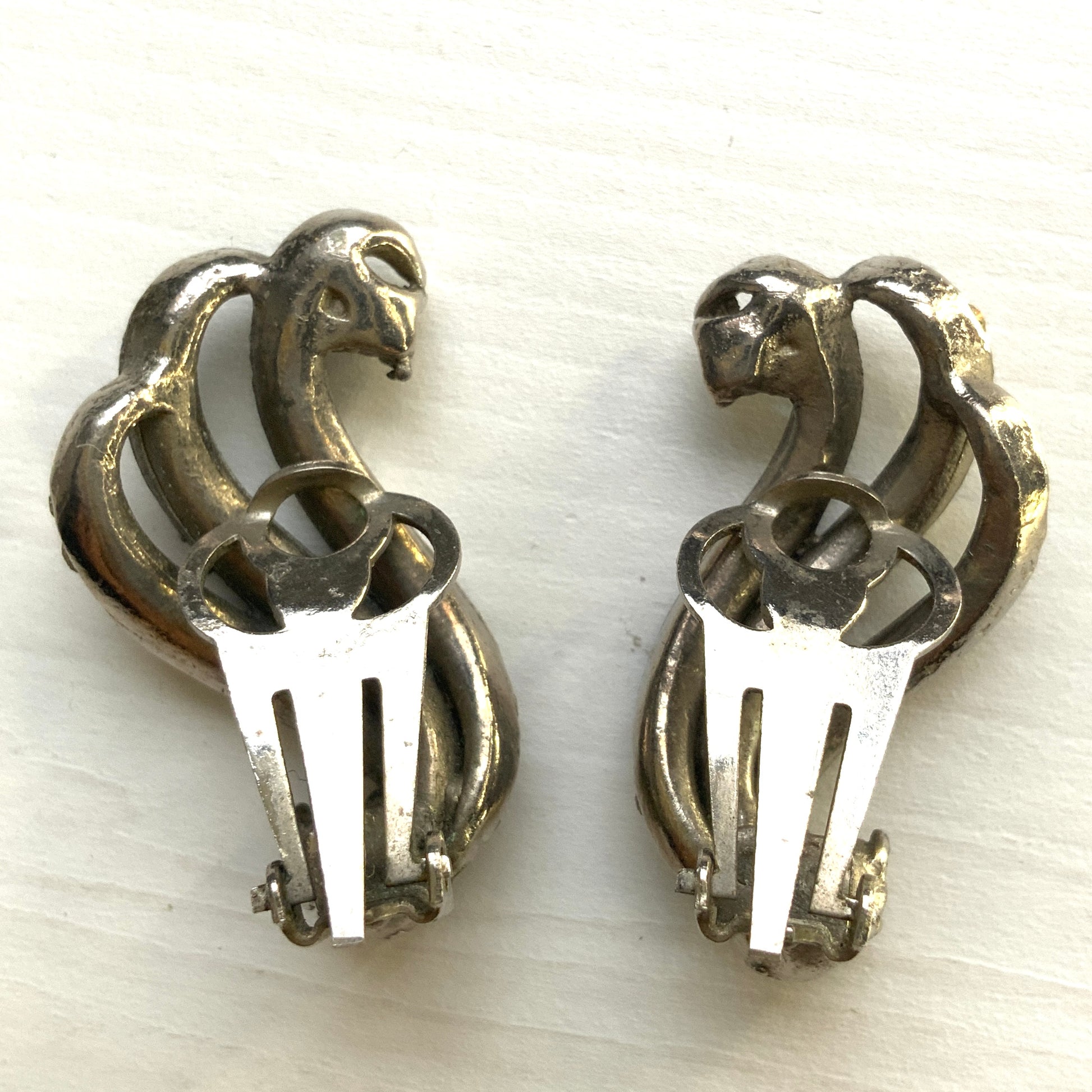 Clip-on earrings featuring aurora borealis rhinestones that trace a graceful curved line. 虹色に輝くオーロラストーンが緩やかなラインを描くクリップイヤリング。