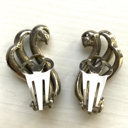 Clip-on earrings featuring aurora borealis rhinestones that trace a graceful curved line. 虹色に輝くオーロラストーンが緩やかなラインを描くクリップイヤリング。