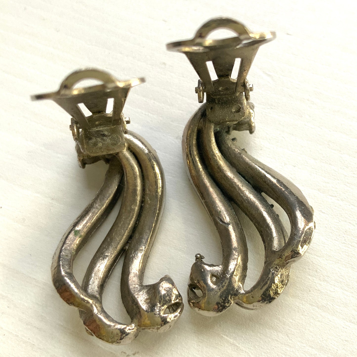 Clip-on earrings featuring aurora borealis rhinestones that trace a graceful curved line. 虹色に輝くオーロラストーンが緩やかなラインを描くクリップイヤリング。