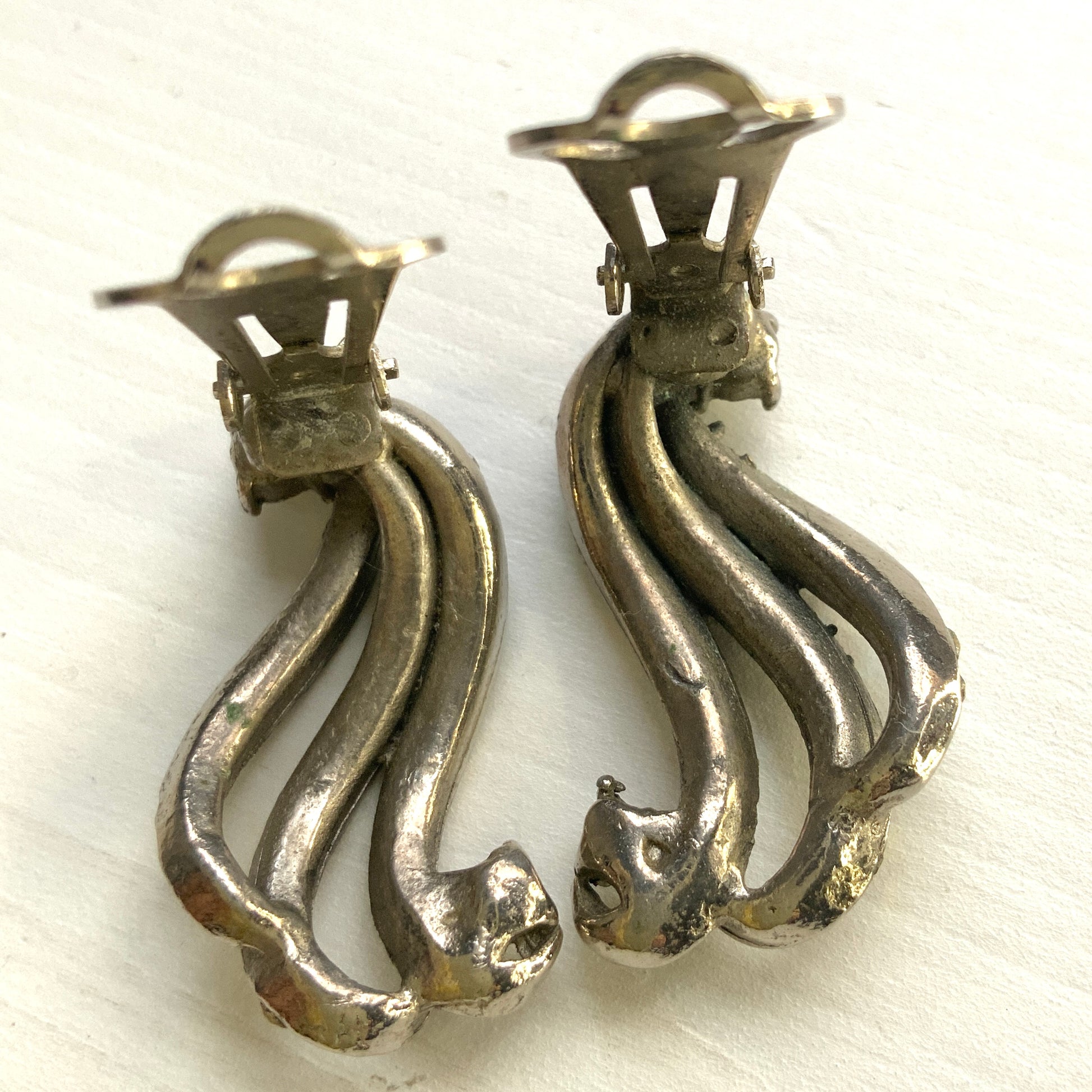 Clip-on earrings featuring aurora borealis rhinestones that trace a graceful curved line. 虹色に輝くオーロラストーンが緩やかなラインを描くクリップイヤリング。