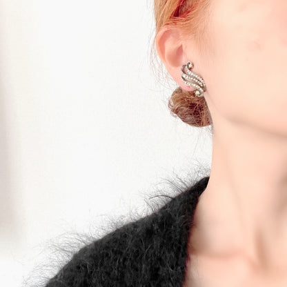Clip-on earrings featuring aurora borealis rhinestones that trace a graceful curved line. 虹色に輝くオーロラストーンが緩やかなラインを描くクリップイヤリング。