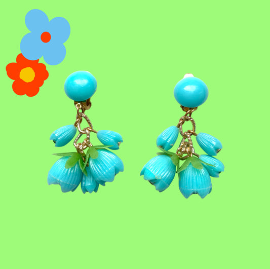 A pair of vintage clip-on earrings featuring dangling turquoise blue plastic flower beads. ターコイズブルーのプラスチックフラワービーズが揺れるヴィンテージクリップイヤリング。