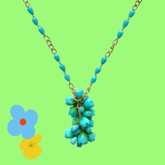 A vintage necklace featuring turquoise blue plastic flower beads that sway beautifully at the neckline.  ターコイズブルーのプラスチックフラワービーズが胸元で揺れるヴィンテージネックレス。