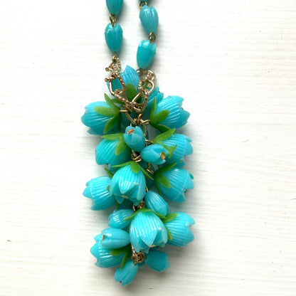 A vintage necklace featuring turquoise blue plastic flower beads that sway beautifully at the neckline.  ターコイズブルーのプラスチックフラワービーズが胸元で揺れるヴィンテージネックレス。